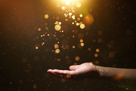 Unknown hand holding abstract shiny gold powder .の写真素材