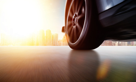 Low angle side view of car driving fast at sunset with motion speed effect .の写真素材