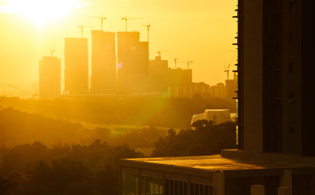 High buildings under construction with cranes at evening with modern apartment living block of flats...
