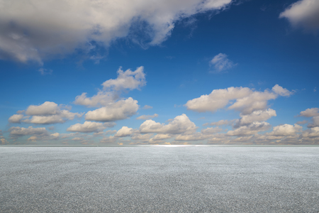 Empty asphalt floor with white clouds and blue sky .の写真素材