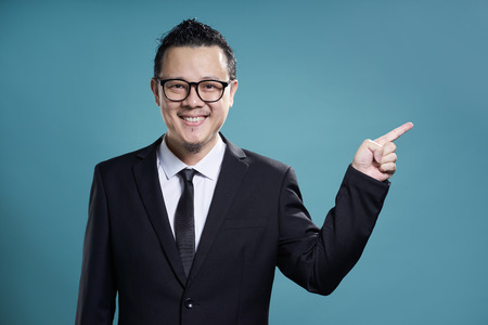 Asian businessman finger pointing to the side . figure out and guiding concept .の写真素材
