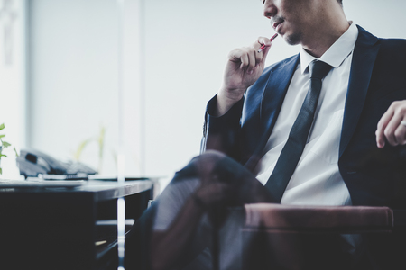 Businessman thinking Ideas sitting at his desk in a office .の写真素材