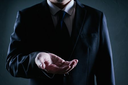 Businessman hold gesture pose . Low key lighting .の写真素材