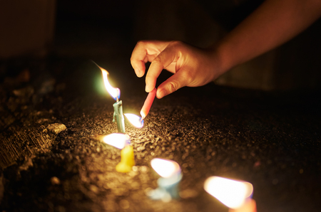 Unknown hand lighting a candles in a night .の写真素材