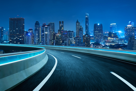 Blue neon light highway overpass motion blur with city  skyline background , night scene .の写真素材