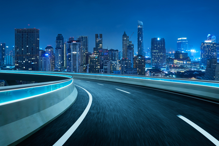 Blue neon light highway overpass motion blur with city  skyline background , night scene .の素材 [FY310117166661]