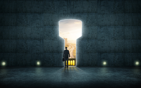 Hesitant businessman stand on wall with digital usb key hole door ,sunrise scene city skyline outdoor view .の写真素材