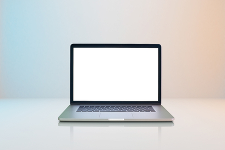 Laptop with white blank screen on milky white background with slightly blue and orange lighting .の写真素材