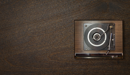 Old vintage retro wooden vinyl record player on wooden background , oldy music entertainment , top view .の写真素材