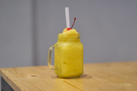Mango ice blended with cherry on wood table .の写真素材