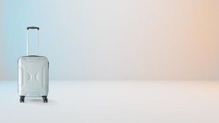 Silver hand carry luggage on milky white background with slightly blue and orange lighting .の写真素材
