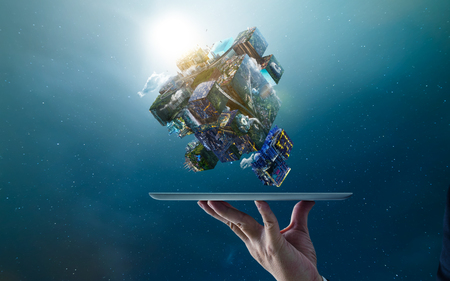 Waiter hand holding an digital tablet with fantasy puzzle cube of city and landscapes floating in the air , smart and creative city  global concept . Mixed mediaの写真素材