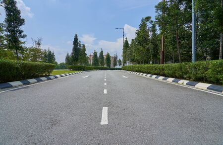 The asphalt road in the park with green grass background .の写真素材