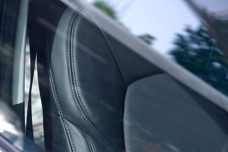 Closeup of a modern car interior with the black leather front seats ,looking through car window from outsideの写真素材