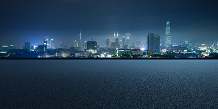 Cityscape skyline night scene with empty asphalt floor on frontの写真素材