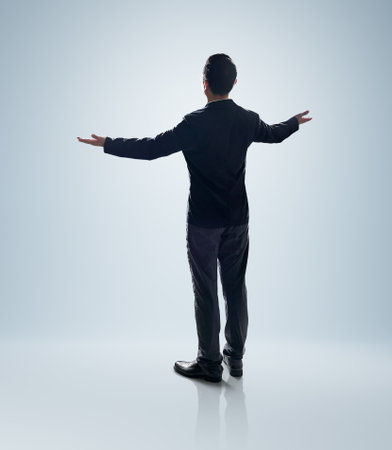 Rear view angle of Businessman standing and lift up the hands pose. Isolated on white background with clipping path.の写真素材