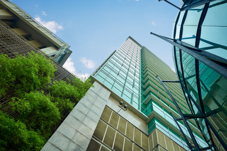 Low angle shot of modern buildings and green with clear sky background.の写真素材