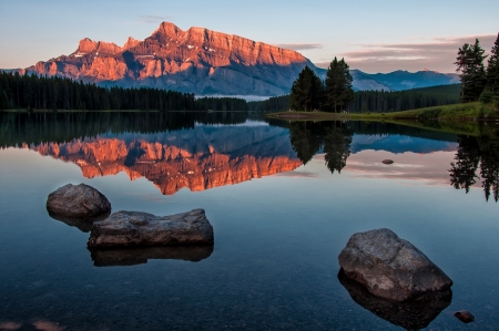 Sunrise reflection of a orange mountain at Lake Minnewanka in Banff National Park, Canada の写真素材