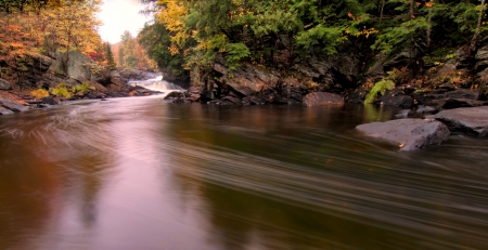 Flowing river with fall colors in the distance の写真素材