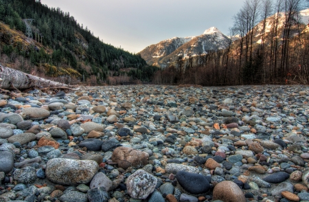 Field of natural stones with mountains and forest in backgroundの写真素材