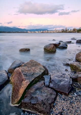 Rocks large in foreground with Vancouver skyline in distanceの写真素材