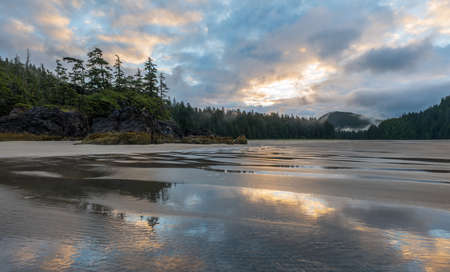 Sun rising behind the clouds on Northern Vancouver Island beach.の写真素材