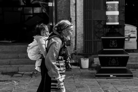 Street view of an elderly piggy back a young childrenのeditorial素材