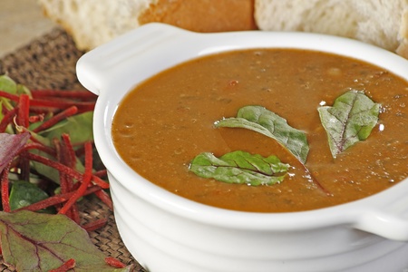 close up of a bowl of hot chick pea spinach and beetroot soupの写真素材