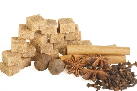 Demerara sugar cubes and a selection of spices on a white backgroundの写真素材