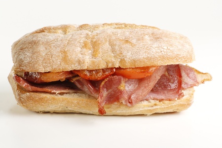 crispy grilled bacon and tomato on a crusty bread rollの写真素材
