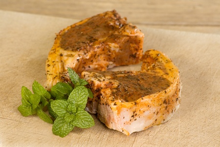 two uncooked minted lamb cutlets on a wooden boardの写真素材