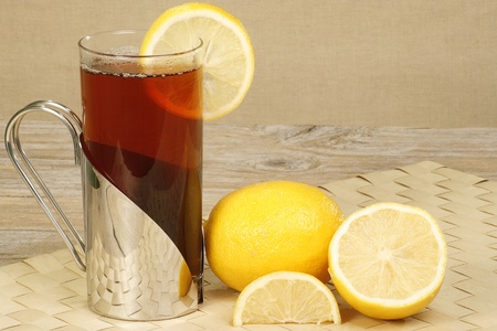 glass mug of refreshing hot lemon tea on a wooden tableの写真素材