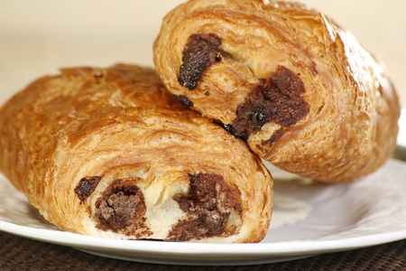 close up of two pain au chocolat on a white plateの写真素材