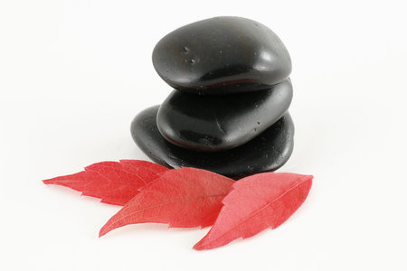three stacked black stones isolated on a white background