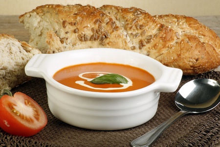 tomato soup and crusty bread on wooden tableの写真素材
