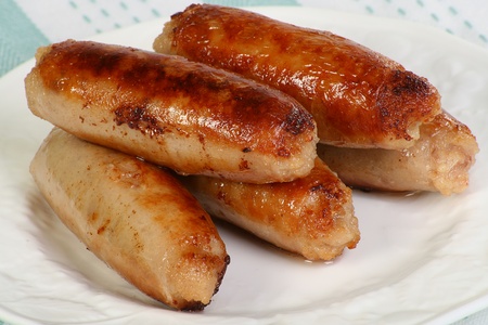 cooked pork sausages on a white plateの写真素材
