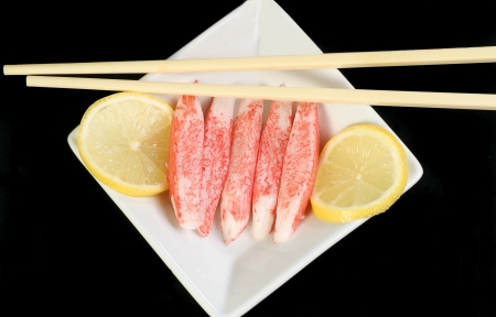 Surimi fish sticks with lemon on a black backgroundの写真素材
