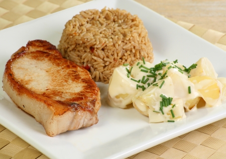 grilled pork loin steak with rice and potato saladの写真素材