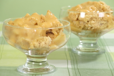 home made apple crumble with custard in a glass bowl の写真素材