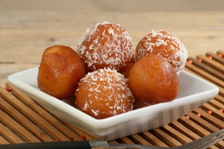 asian gulab jamun on a white dish with coconutの写真素材