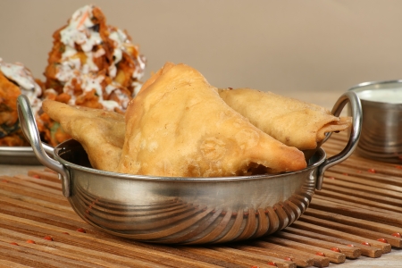 Vegetable samosas served in a metal bowlの写真素材