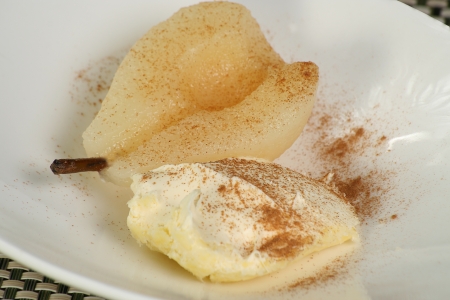 pear poached in sugar syrup with cinnamon and clotted creamの写真素材