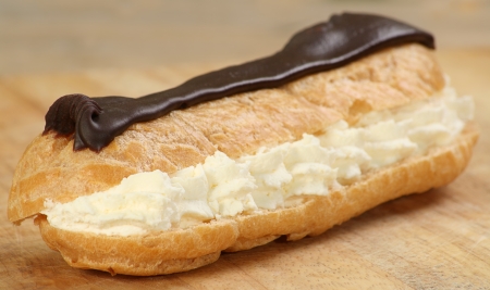 single chocolate and fresh cream cake on a wooden serving boardの写真素材