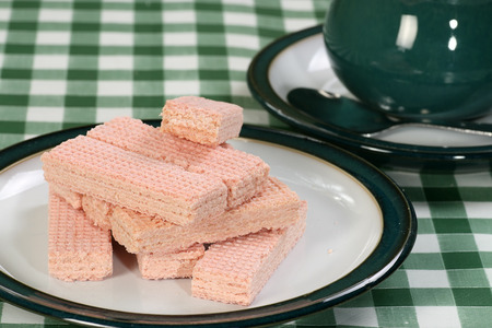 pile of pink wafer biscuits on a green and white plate                               の写真素材