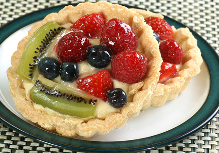 two mixed fruit tarts on a small plateの写真素材