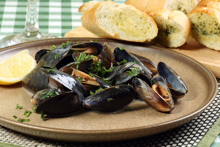 seafood mussels in white wine sauce with parsley and garlic breadの写真素材