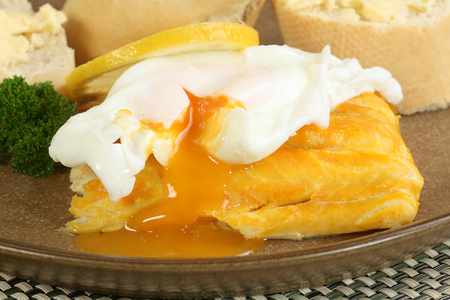 poached smoked haddock with egg and crusty breadの写真素材