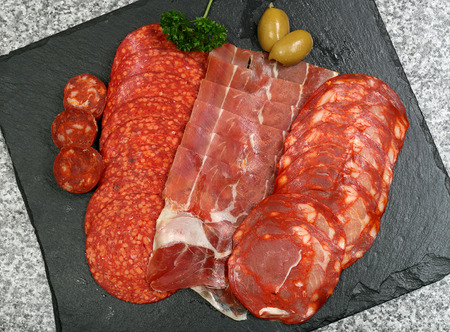 selection of sliced tapas meat on a slate backgroundの写真素材