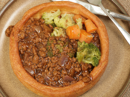 giant yorkshire pudding filled with mince and vegetables and gravyの写真素材