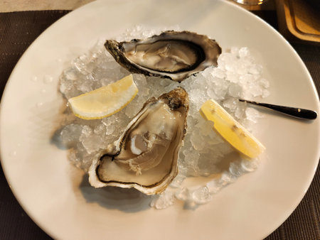 Fresh Oysters with lime on a large plate with ice.